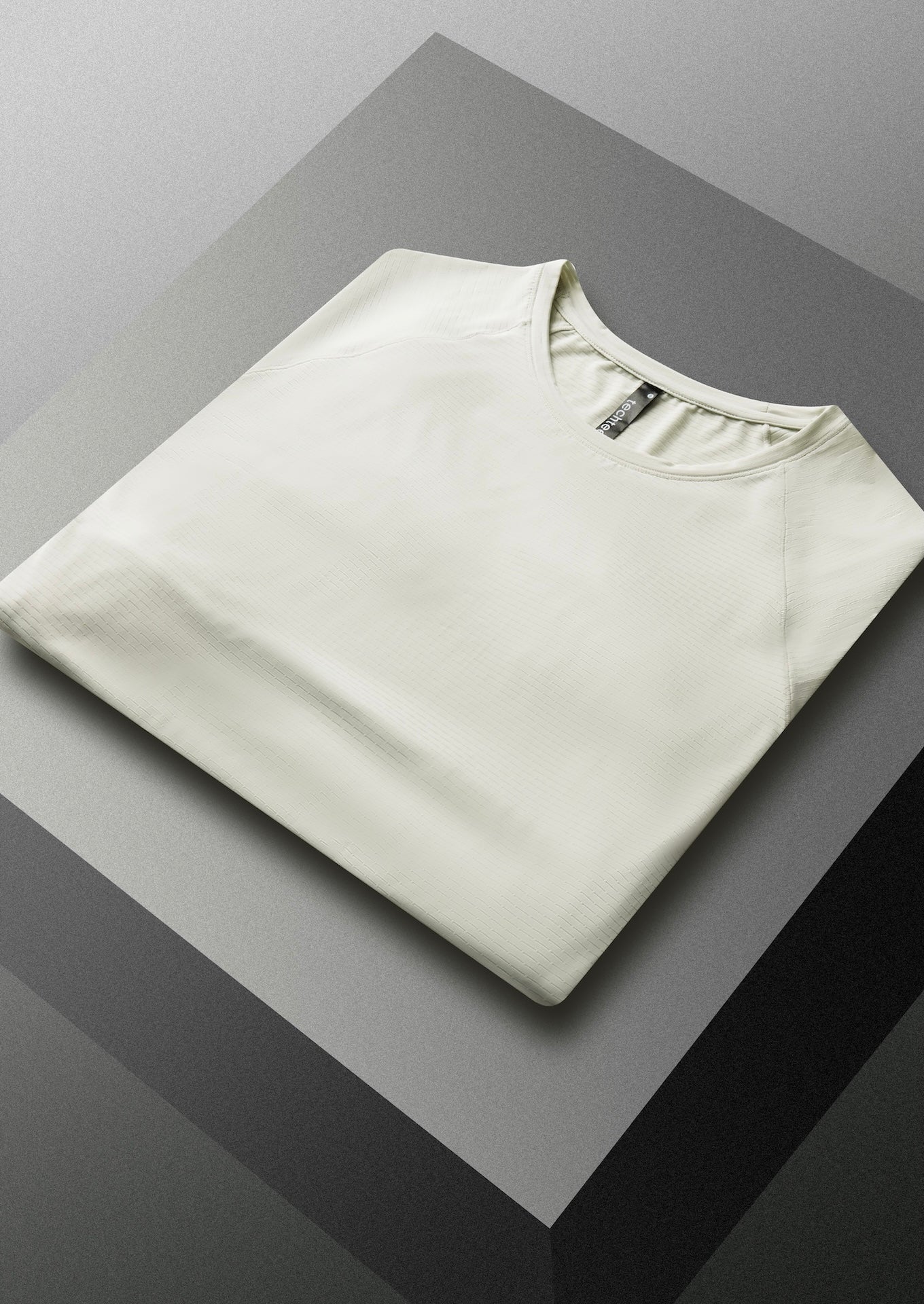 Folded grey shirt on a reflective surface