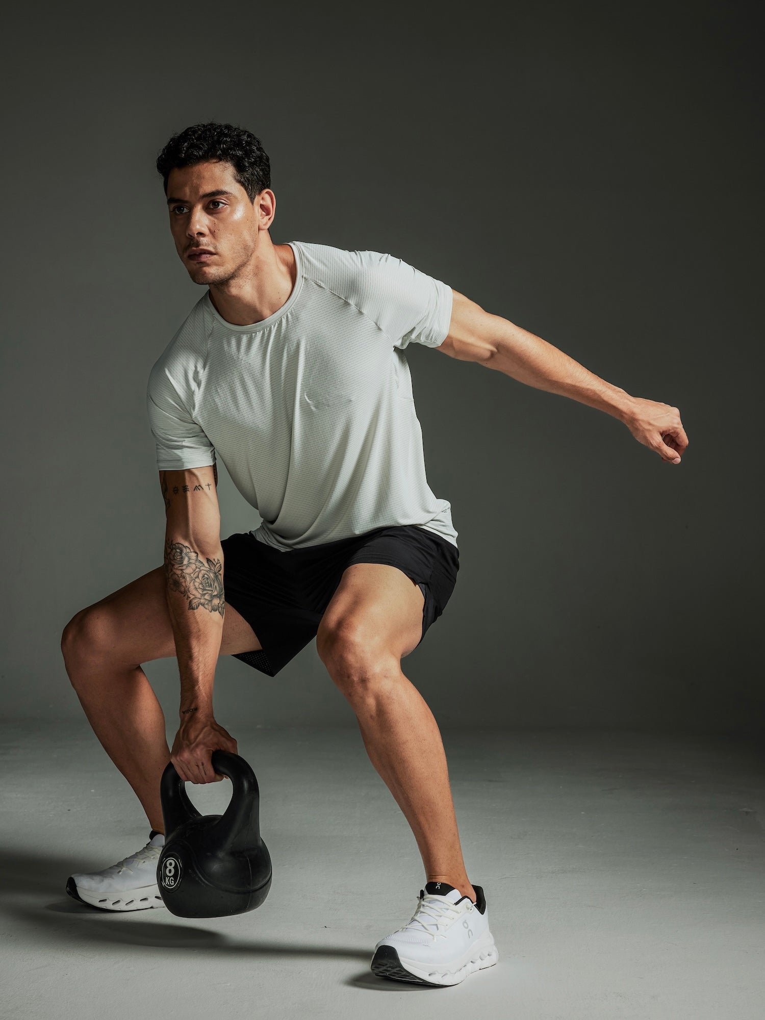 Man exercising with a kettlebell against a dark background